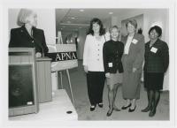 black & white photo of a group of four nurses standing proudly next to the sign of CAPNA